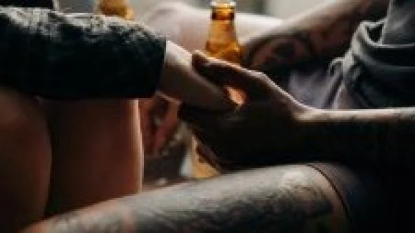 Pareja con tatuajes tomadas de la mano