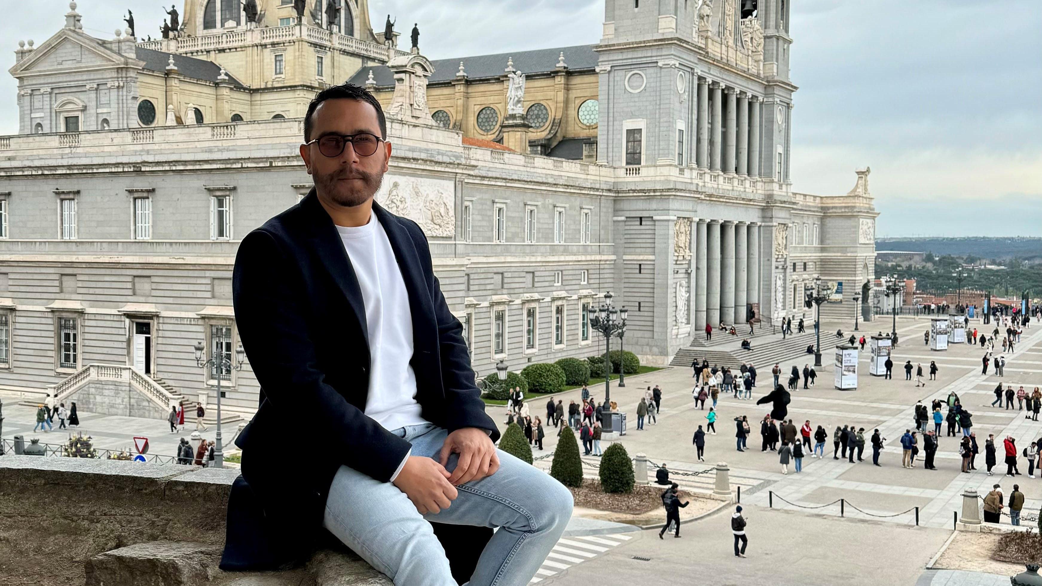 Eladio Duque, sentado con la Catedral de Madrid detrás. 