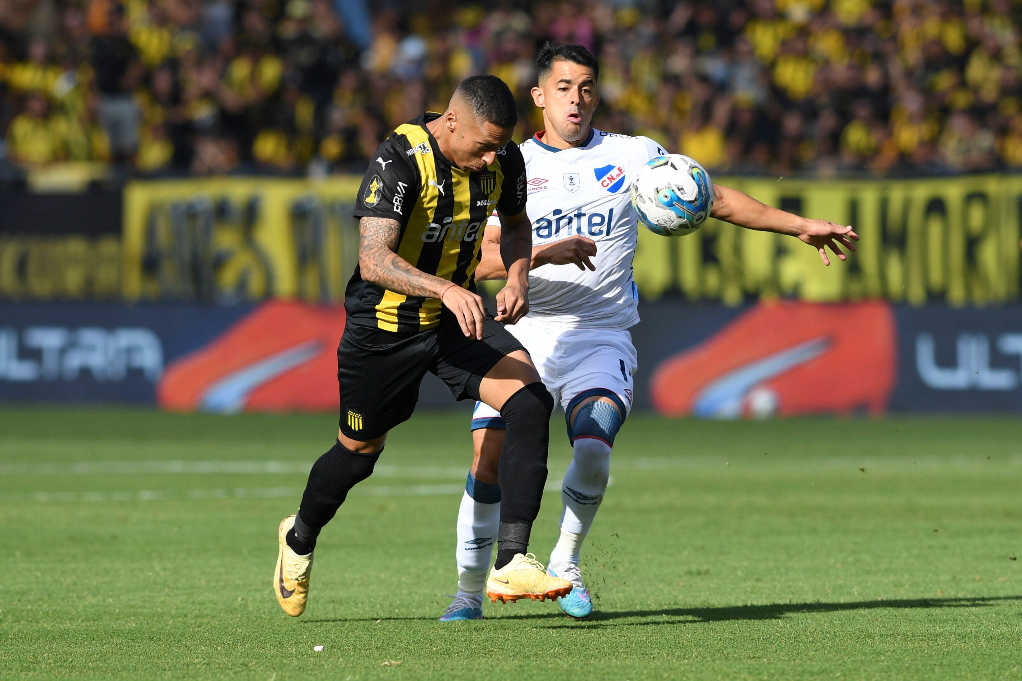 Dos futbolistas de Peñarol y Nacional disputan el balón en el clásico uruguayo