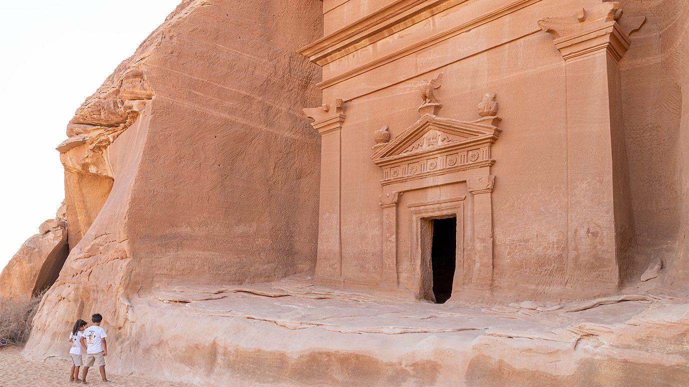 Dos visitantes, junto a una de las ruinas de AlUla. 