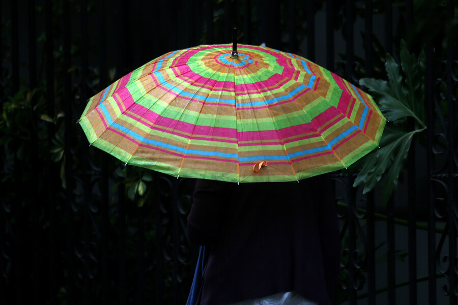 Persona con paraguas bajo la lluvia. Lluvia en Santiago