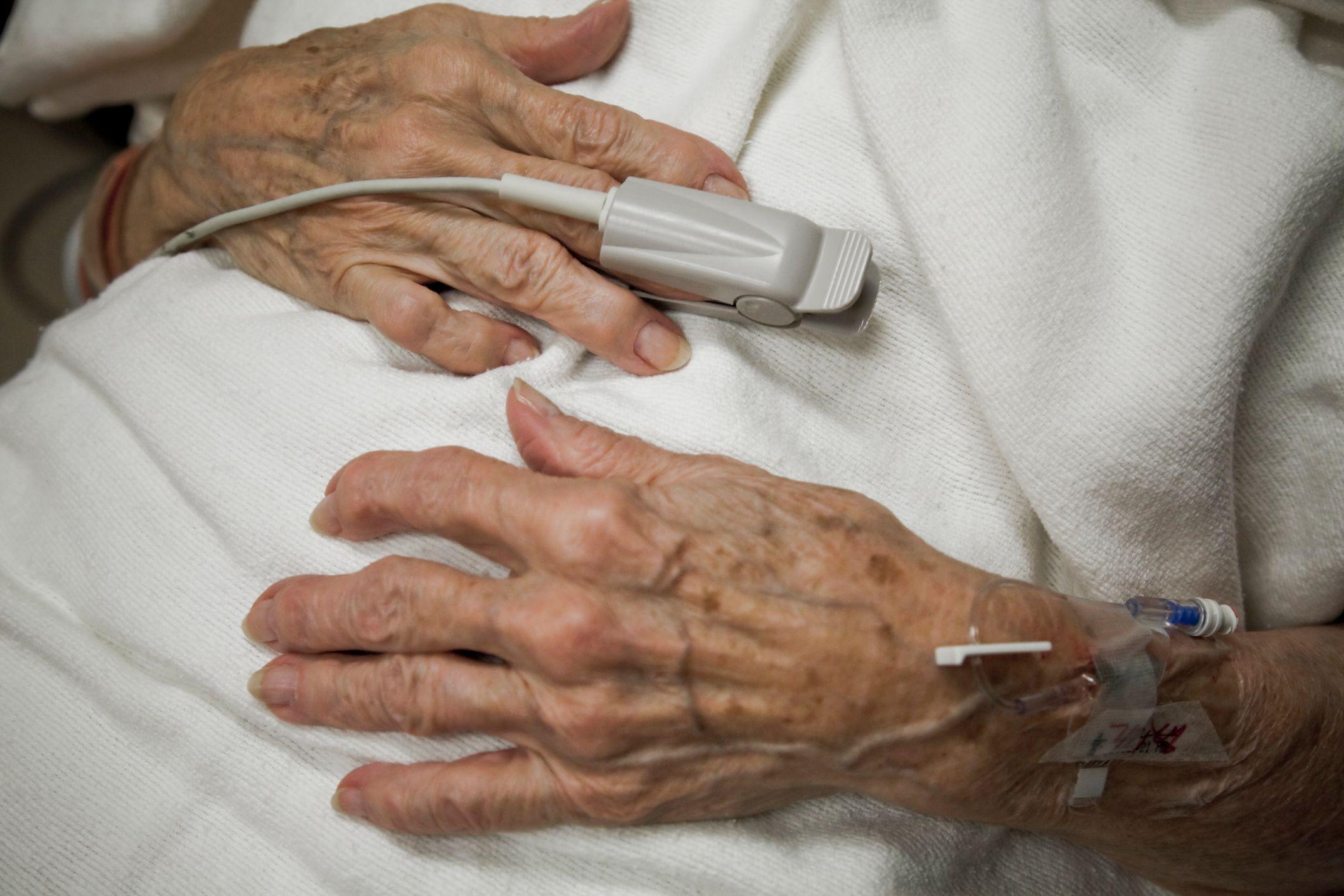 manos de una persona mayor en una cama de hospital 