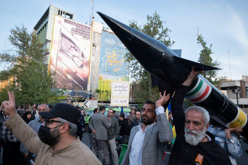 Partidarios del gobierno iraní se manifiestan con la réplica de un cohete en Teherán. 