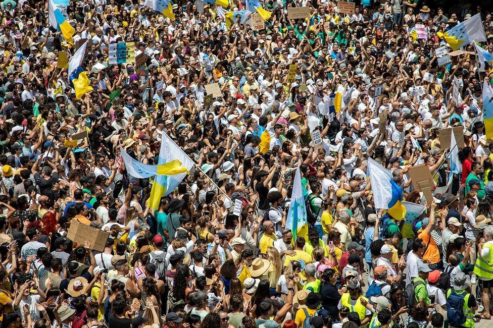 Manifestantes en las calles con banderas y pancartas