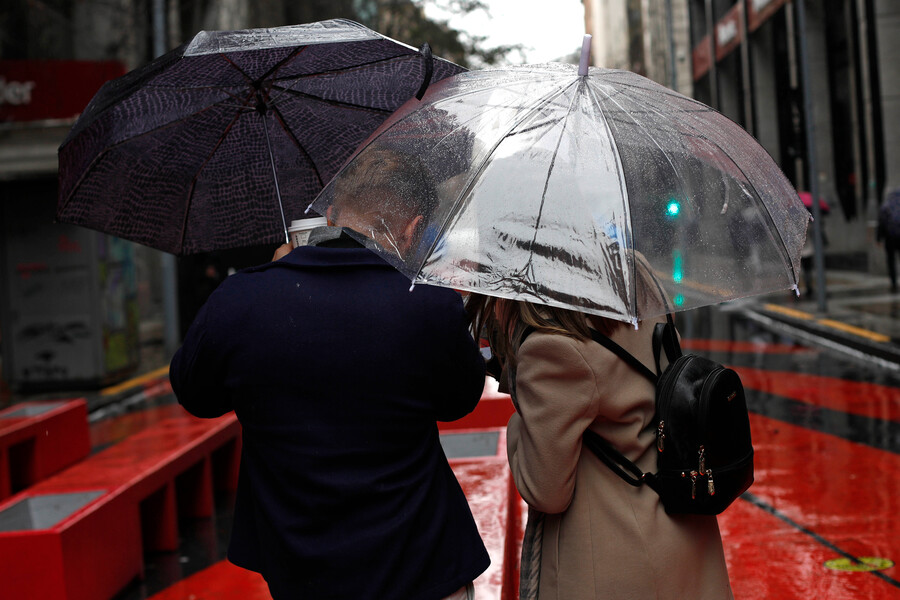 Personas bajo la lluvia en Santiago