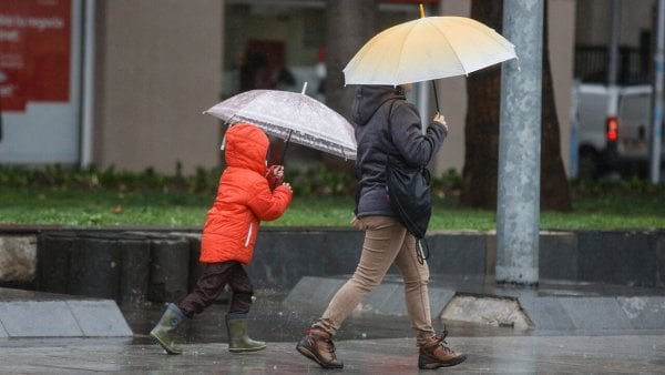 Luvia en Santiago. Personas bajo la lluvia en Santiago