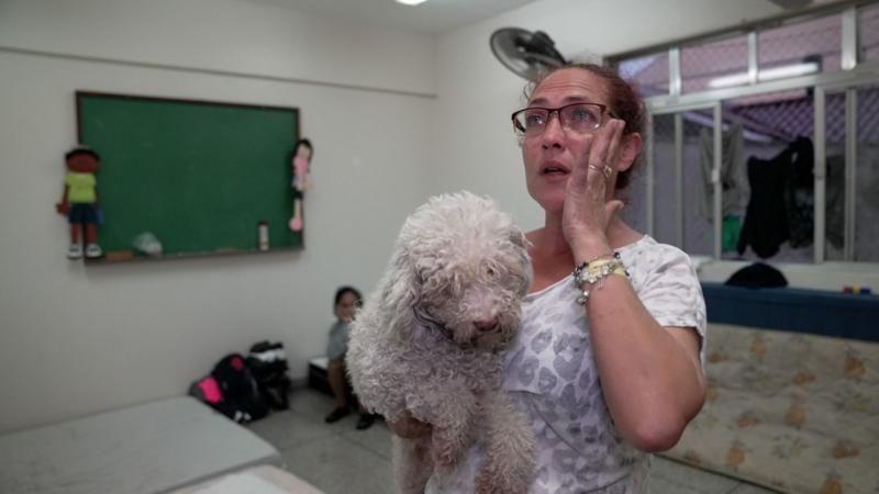 Roselaine da Silva llora al recordar a sus dos gatos que se quedaron en el techo de su casa.