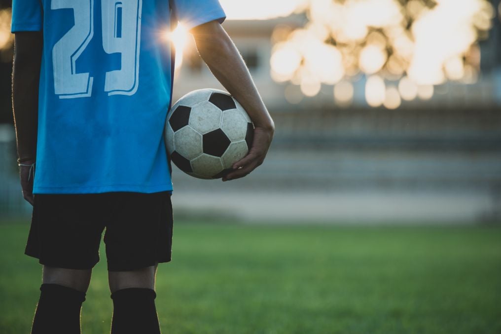 Niño sujetando pelota de fútbol