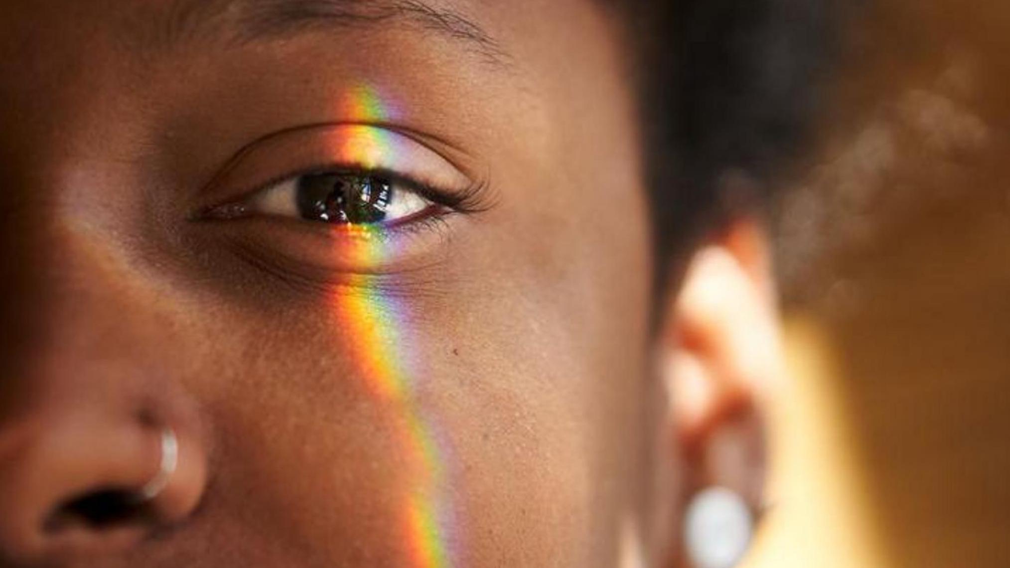 El lado izquierdo de la cara de una mujer con un rayo de luz sobre el ojo