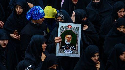 Mujer sostiene la imagen del presidente de Irán