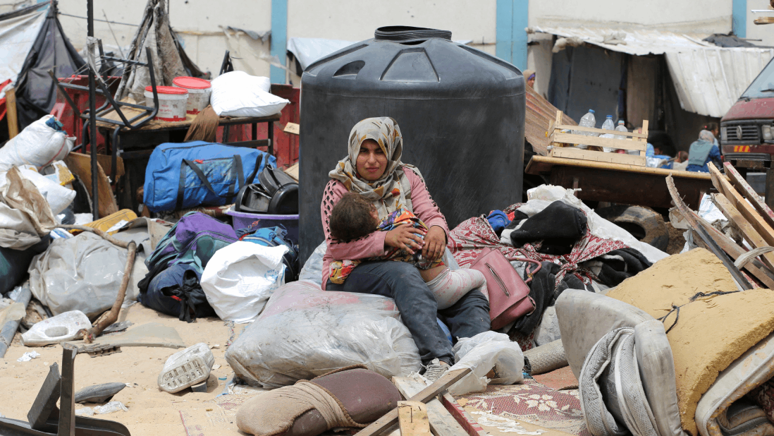 Una mujer abraza a su bebé en medio de la destrucción causada por el ataque de Israel.