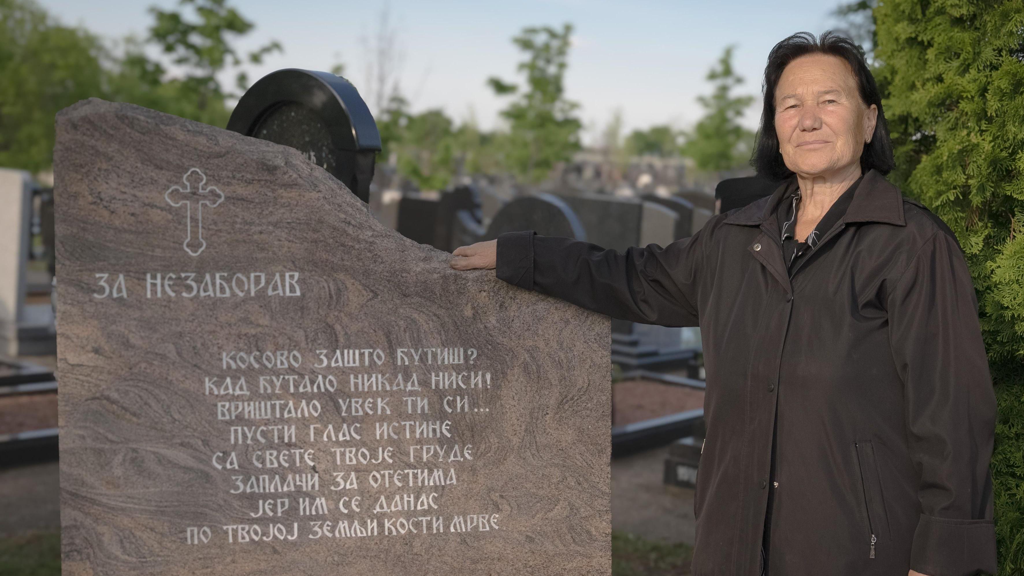 Dragica Majstorovic junto a una placa que recuerda a los desaparecidos de la guerra en Kosovo.