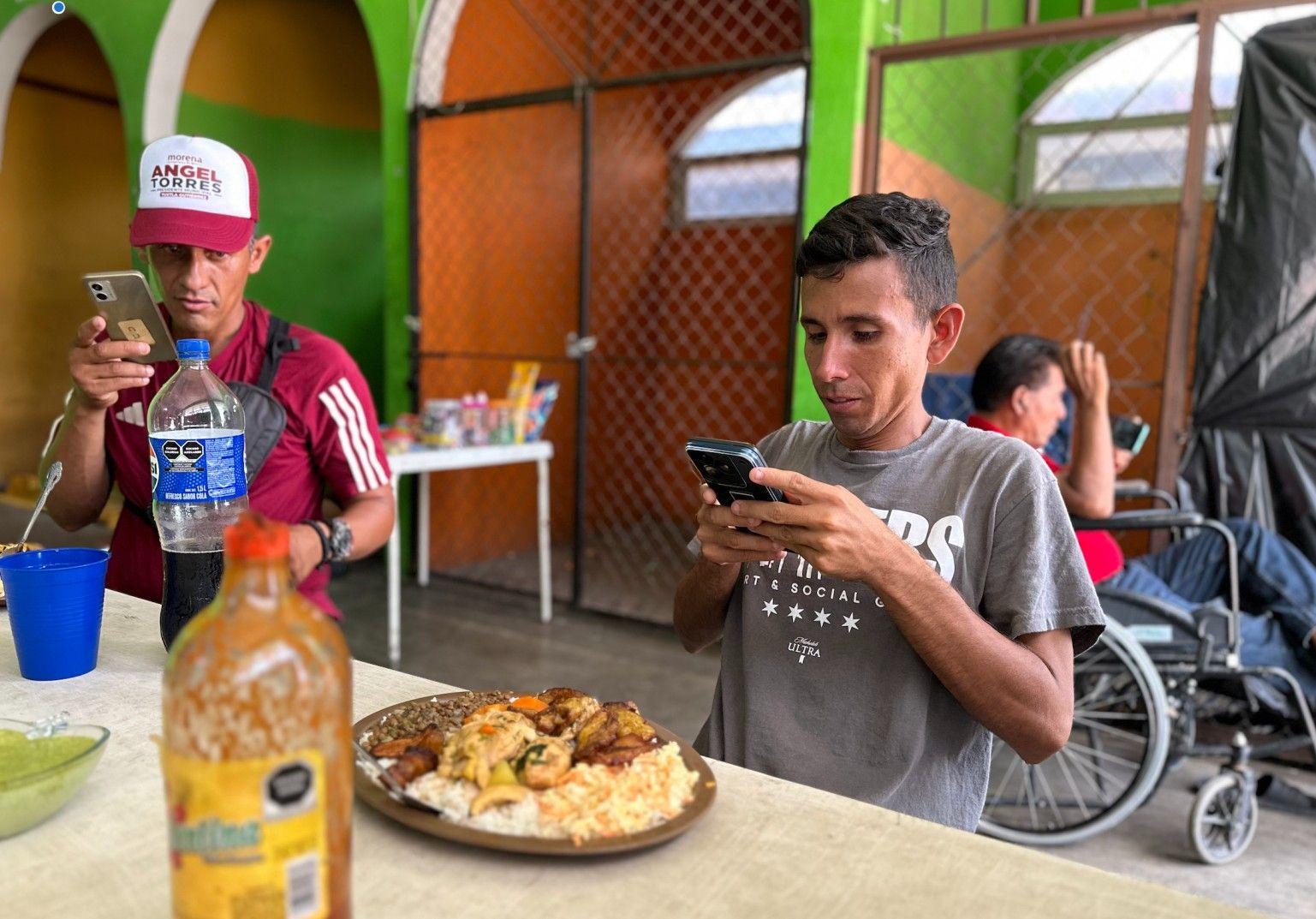 Carlos José Soto, migrante de Carabobo, Venezuela, saca una foto a su ansiado almuerzo venezolano.