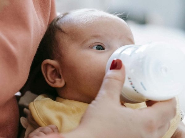 Niños chilenos recibiendo Leche Purita en un consultorio, mostrando la distribución y el impacto de la política pública en la nutrición infantil. Chile, 2024.