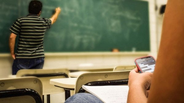 Estudiantes utilizando teléfonos celulares en el aula para actividades educativas. Chile, 2024.