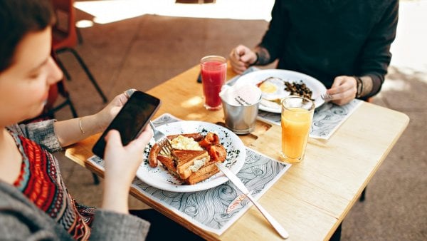 Comer y ver celular.