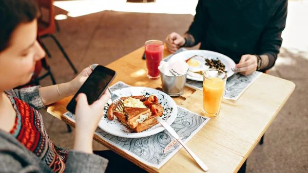 Comer y ver celular.