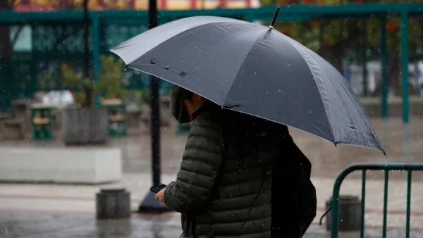 Persona bajo la lluvia con paraguas. Advertencia por lluvias Meteorología.