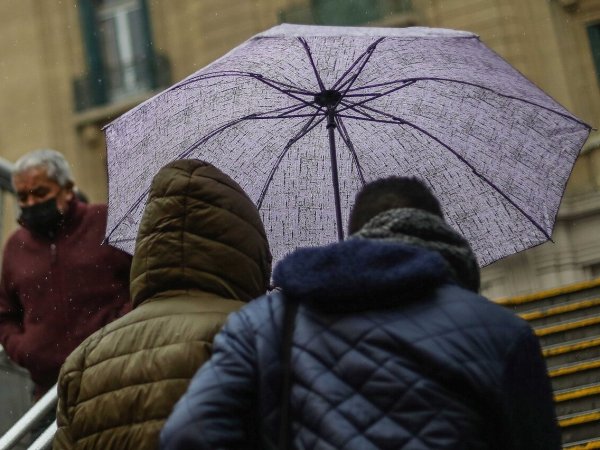 Personas bajo la lluvia con paraguas.