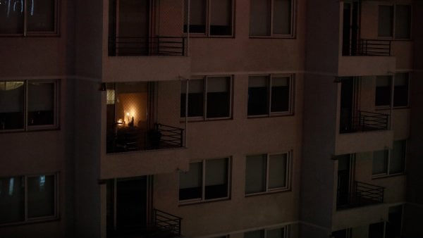 Hombre caminando a la par de protesta nocturna en Pudahuel, donde se ha interrumpido el servicio de luz por 12 días