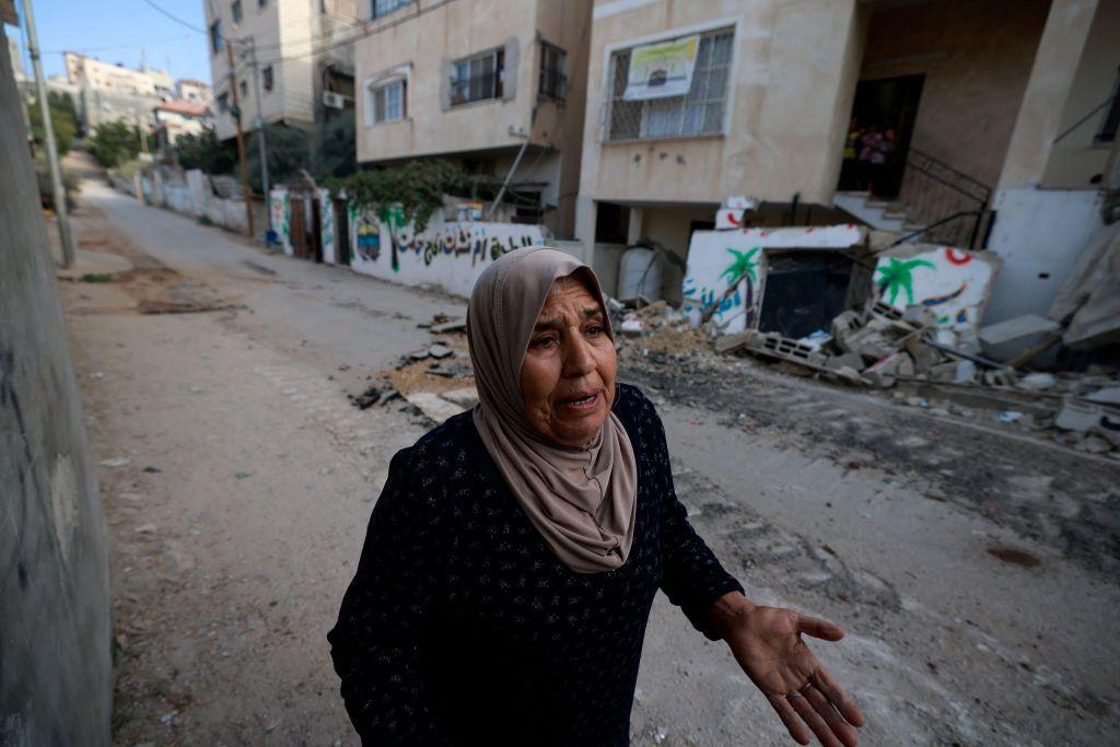 Una mujer camina por una calle afectada por las bombas israelíes en el campo de refugiados de Nur Shams.