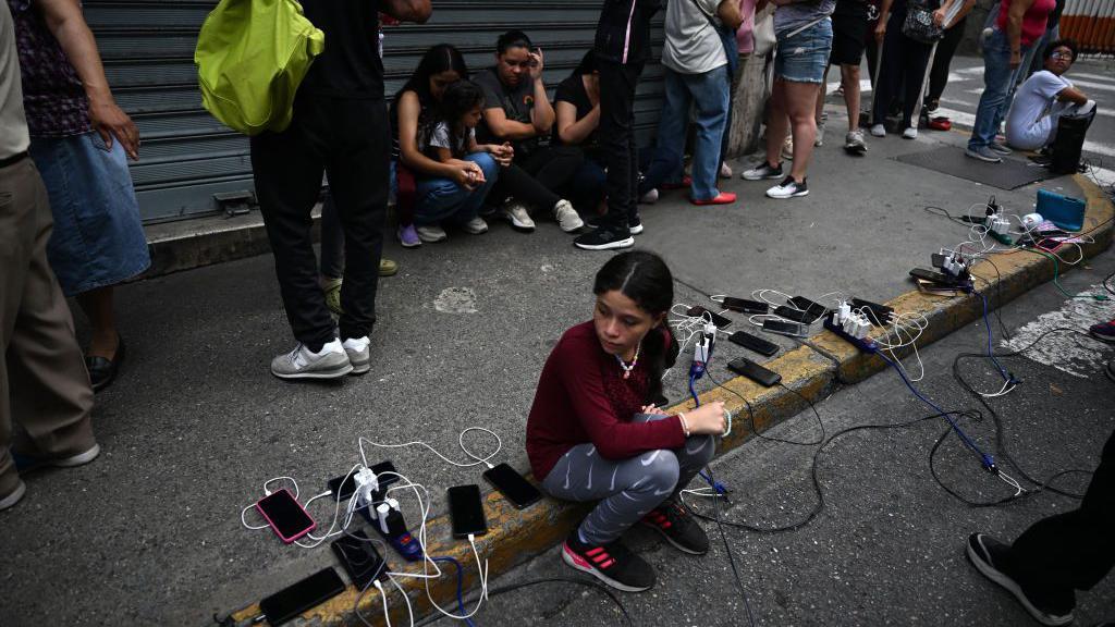 Venezolanos cargando celulares.