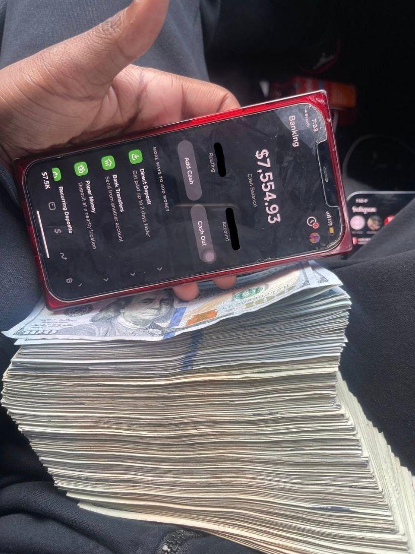 Foto con un celular y una gran cantidad de dinero en efectivo.