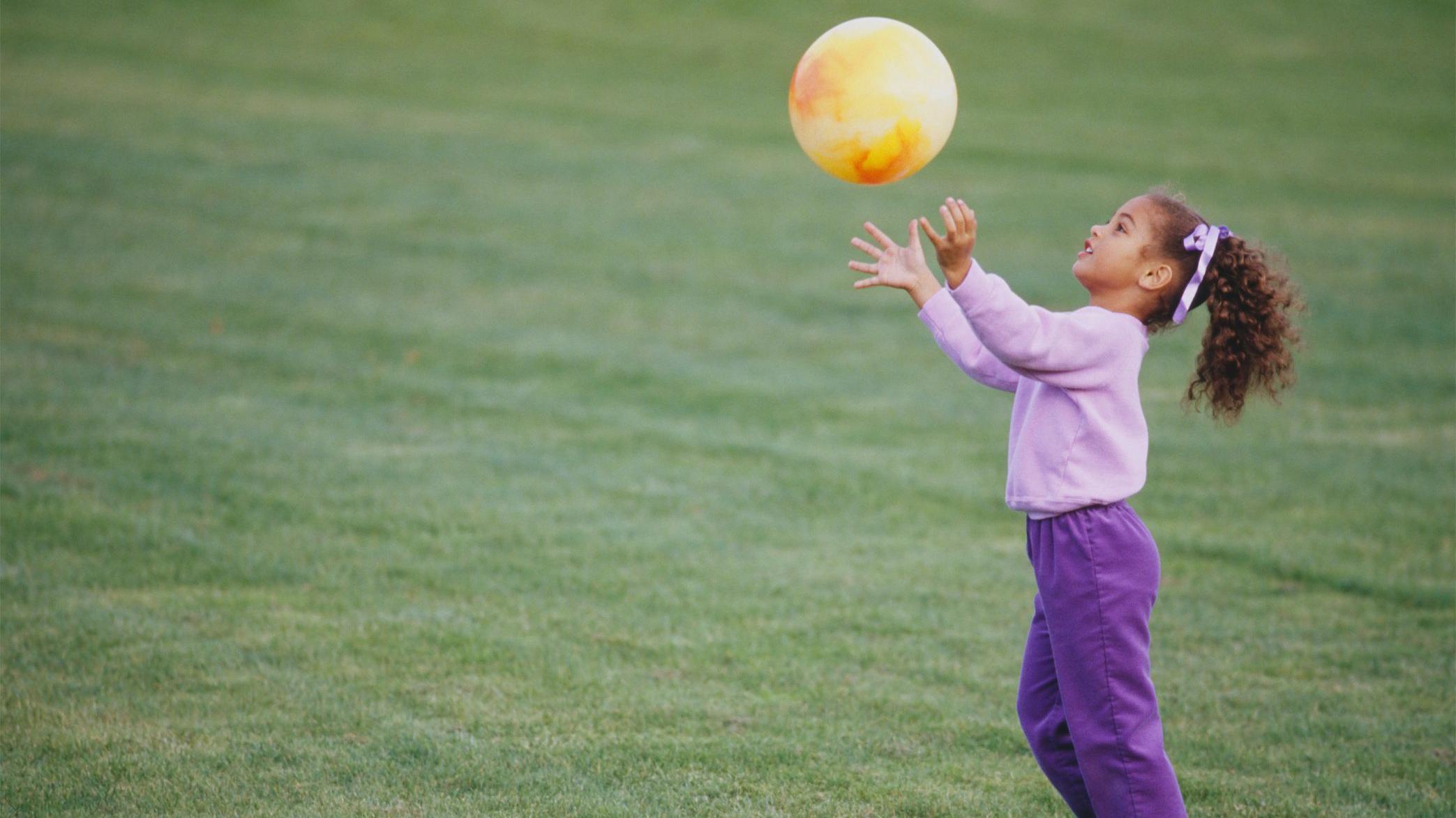 Niña atrapando una pelota.