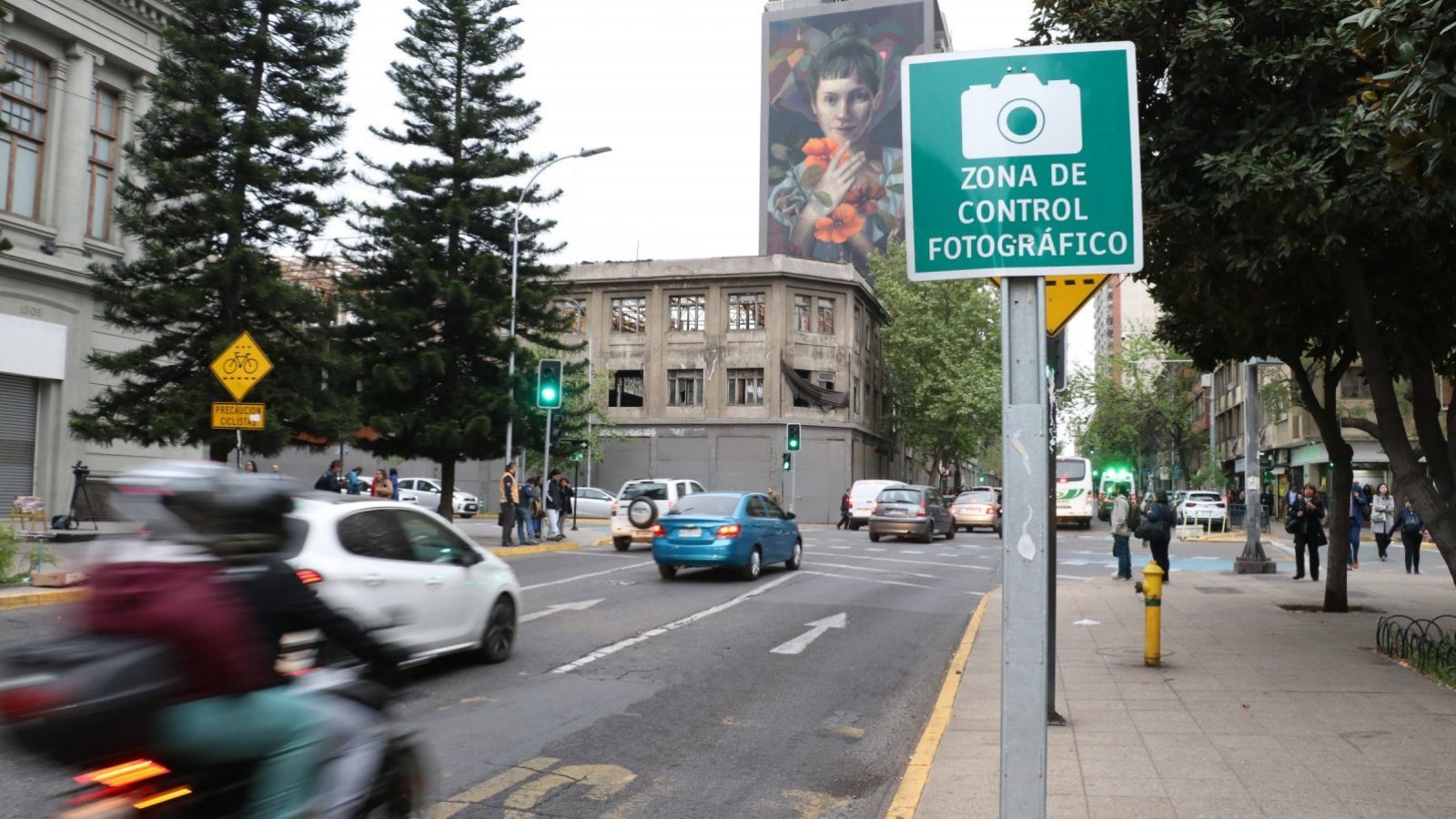 Imagen mostrando una calle con un cartel leyendo "zona de control fotográfico".