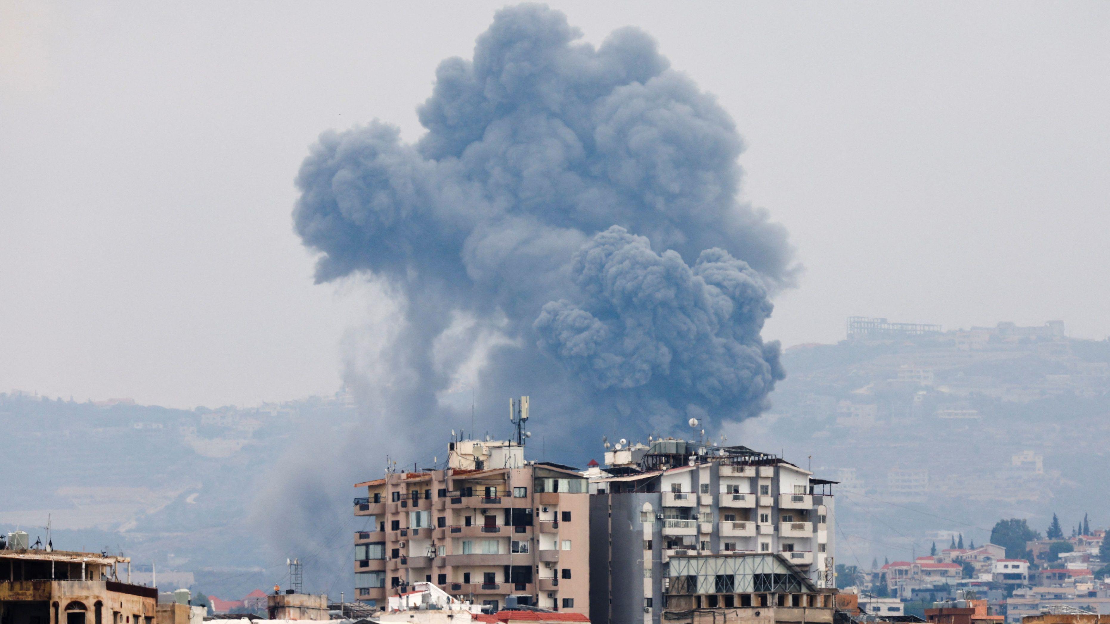 Humo de los bombardeos israelies entre edificios en Tiro en el sur del Líbano el 7 de octubre de 2024