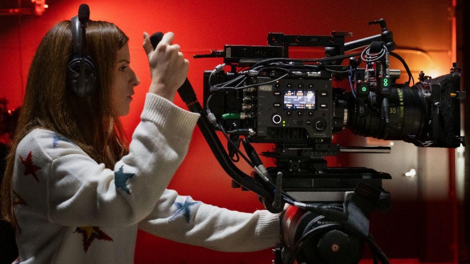 Anna Kendrick en el set de Woman of the Hour. Lleva auriculares y maneja una gran cámara de cine.