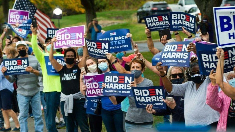 Simpatizantes demócratas agitan pancartas a favor de Biden y Harris en la campaña electoral de 2020.