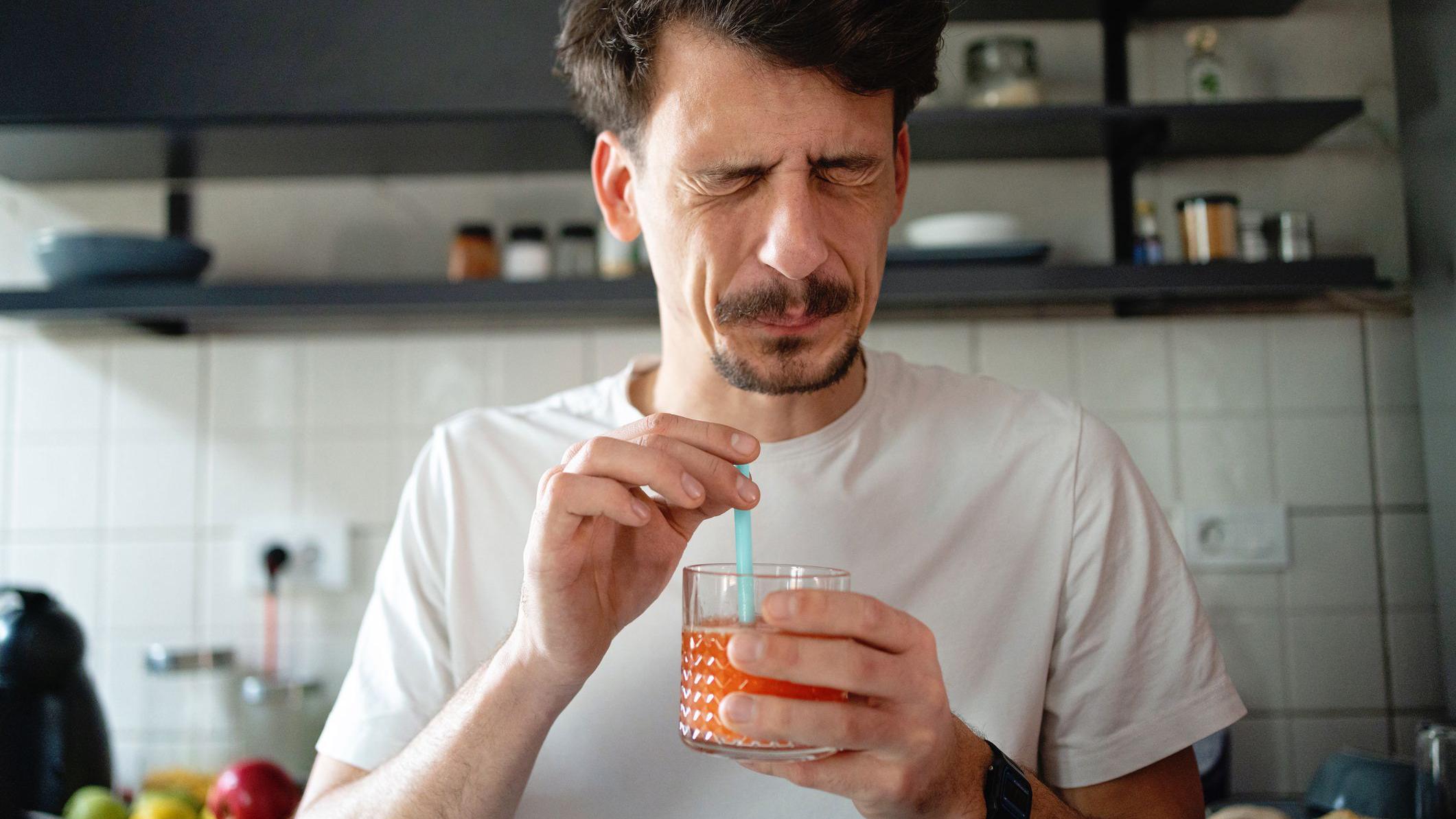Hombre bebiendo un trago amargo.