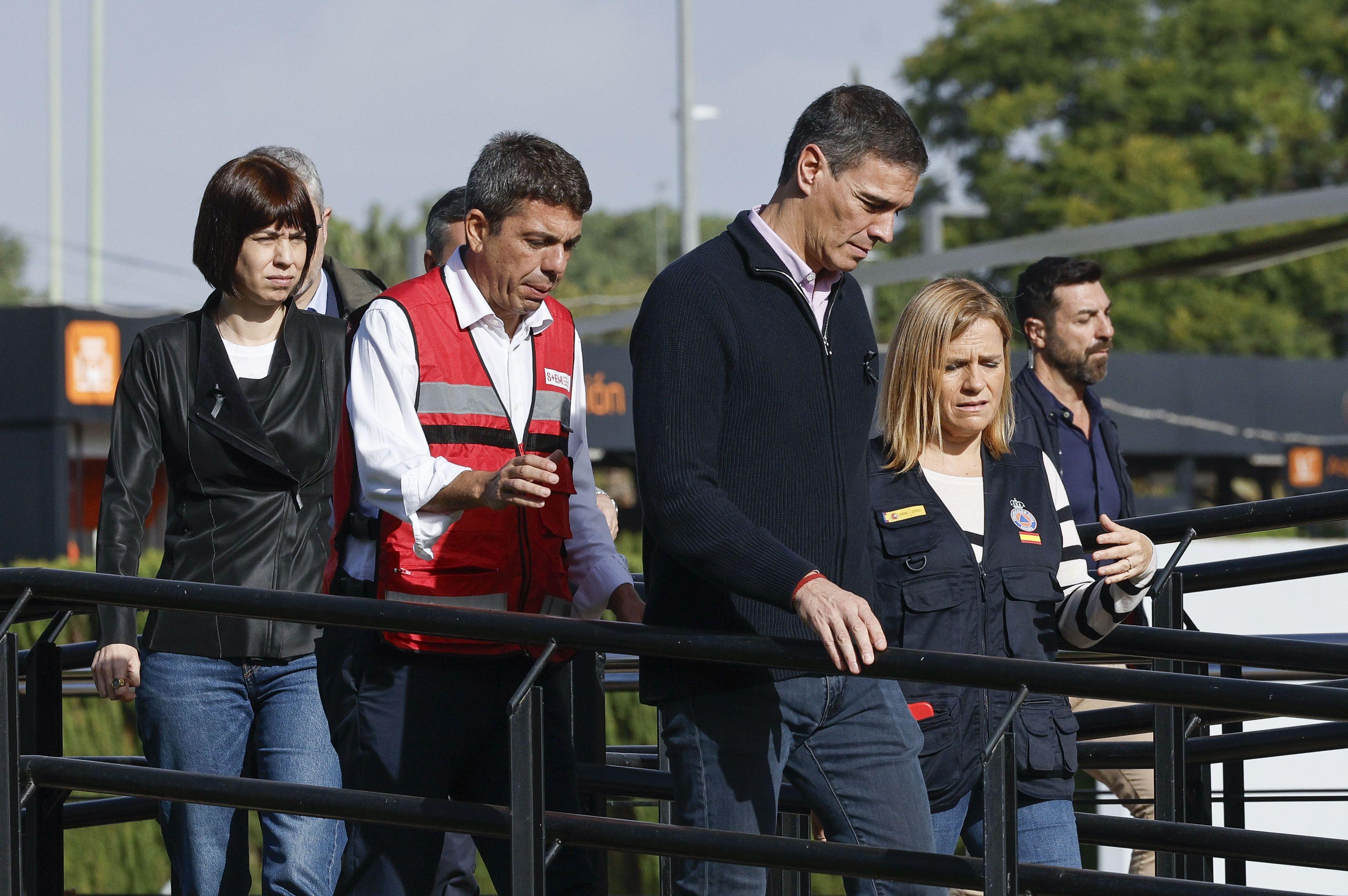 El presidente del gobierno español, Pedro Sánchez, camina seguido de Carlos Mazón, presidente del gobierno regional de la Comunidad Valenciana, y otras autoridades.