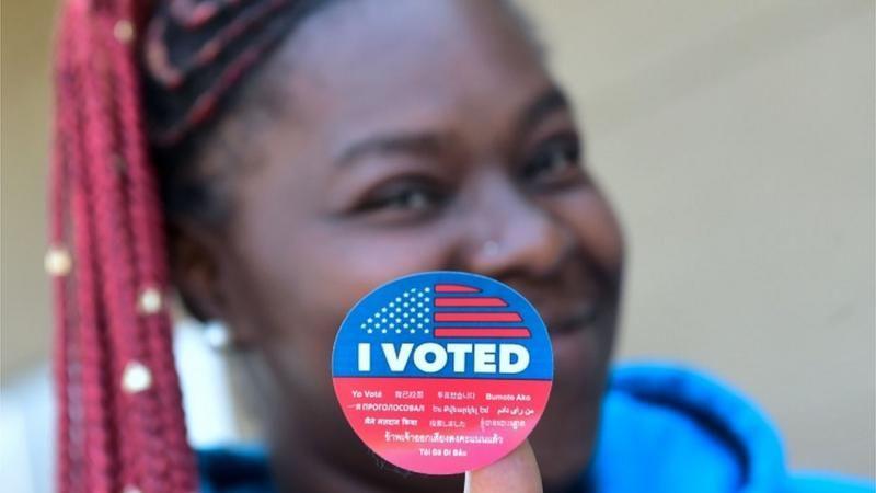 Mujer lleva un letrero que dice "Yo voté".