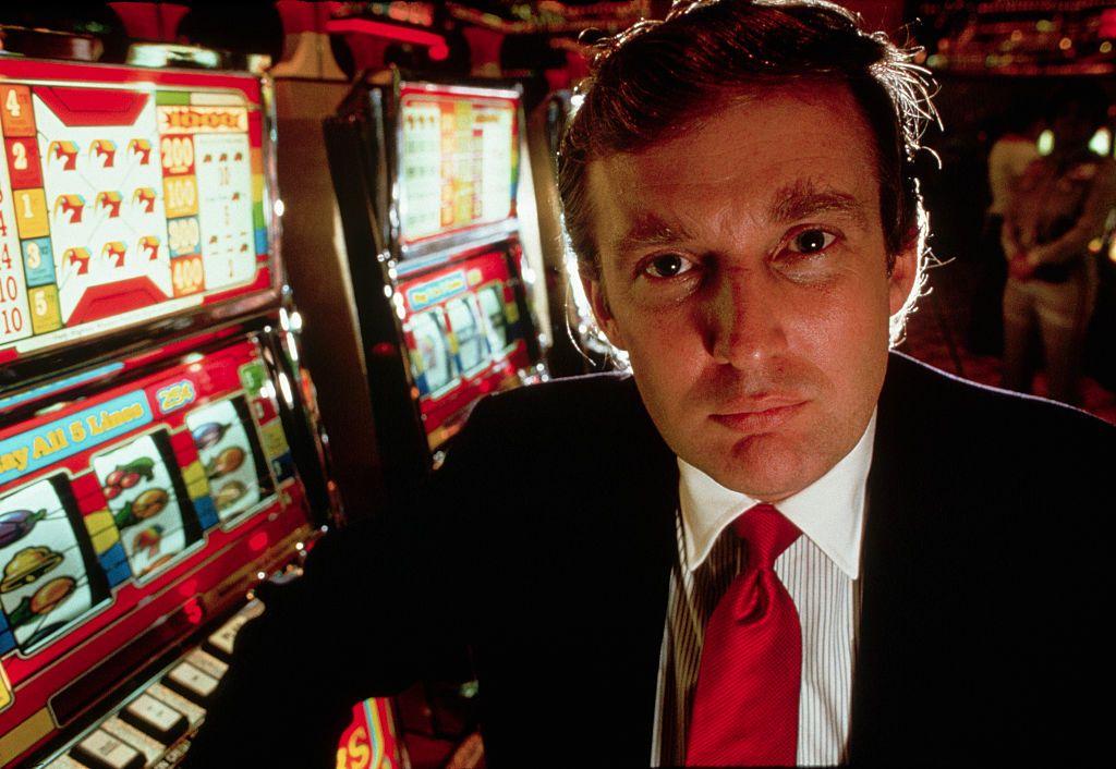 Donald Trump frente a unas máquinas tragamonedas durante la inauguración del casino Taj Mahal, en Atlantic City, Nueva Jersey