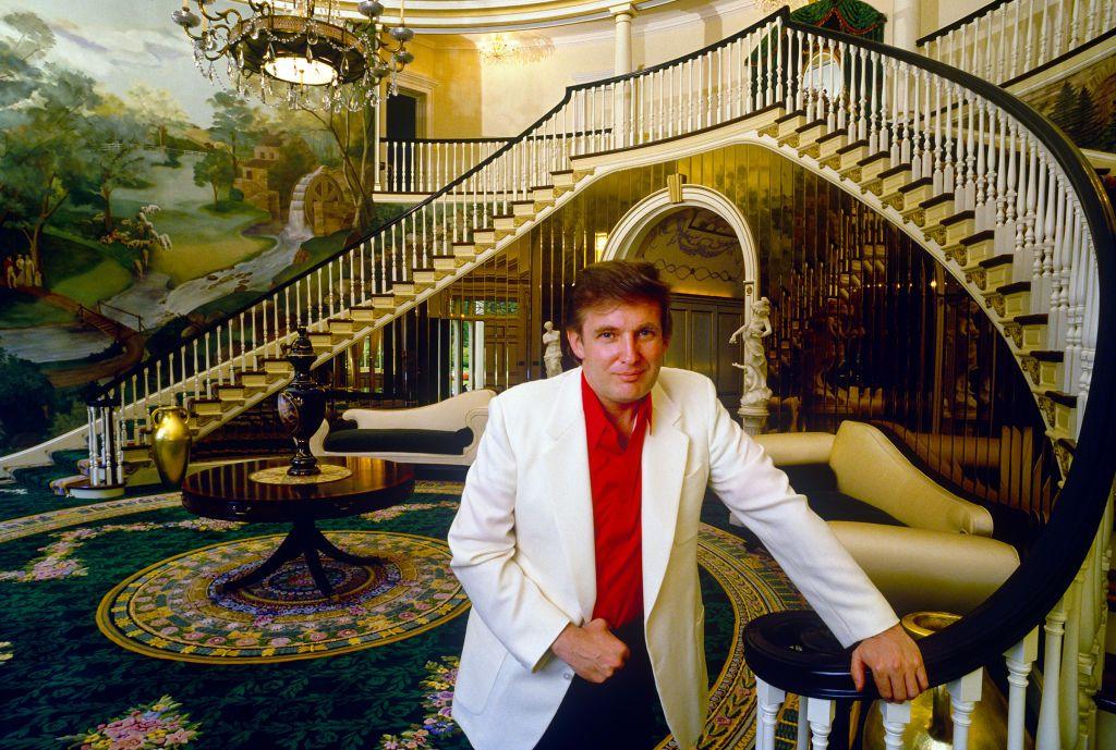 Donald Trump, vestido con camisa roja y chaqueta blanca en la sala de recepción de su mansión