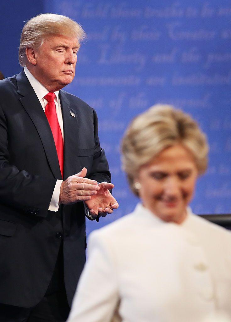 Hillary Clinton deja el escenario mientras Donald Trump aplaude durante un debate