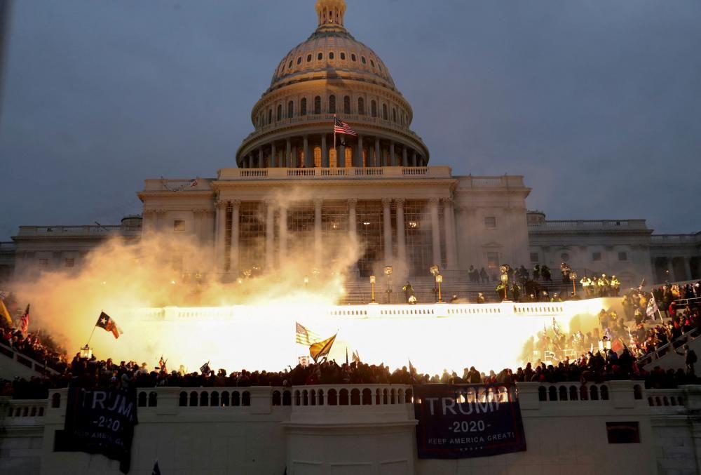 Una explosión causada por el disparo de un policía ilumina el frente del Capitolio en Washington DC, el 6 de enero de 2021