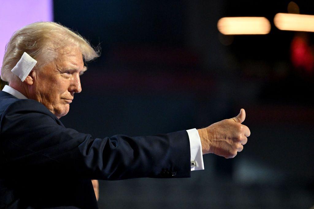 Donald Trump hace una señal con el pulgar durante la Convención Nacional Republicana en Milwaukee. Tiene una venda blanca en su oreja derecha