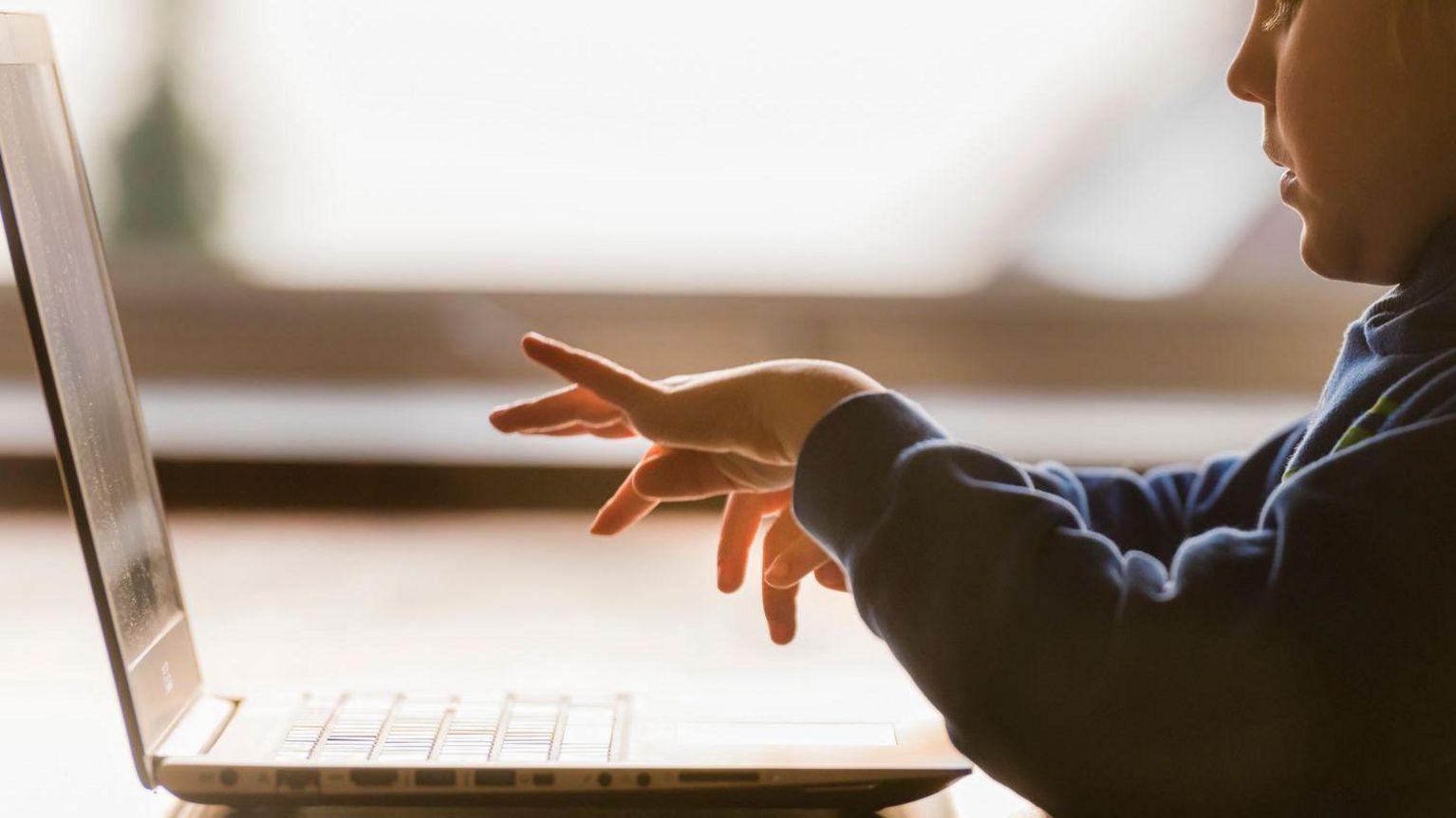 un niño escribe en un computador