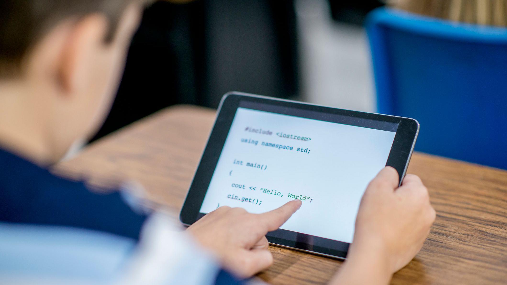 niño mira un lenguaje de programación en una tablet