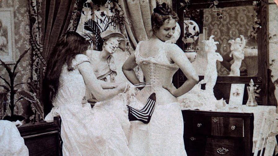 Mujer poniéndose un corset.