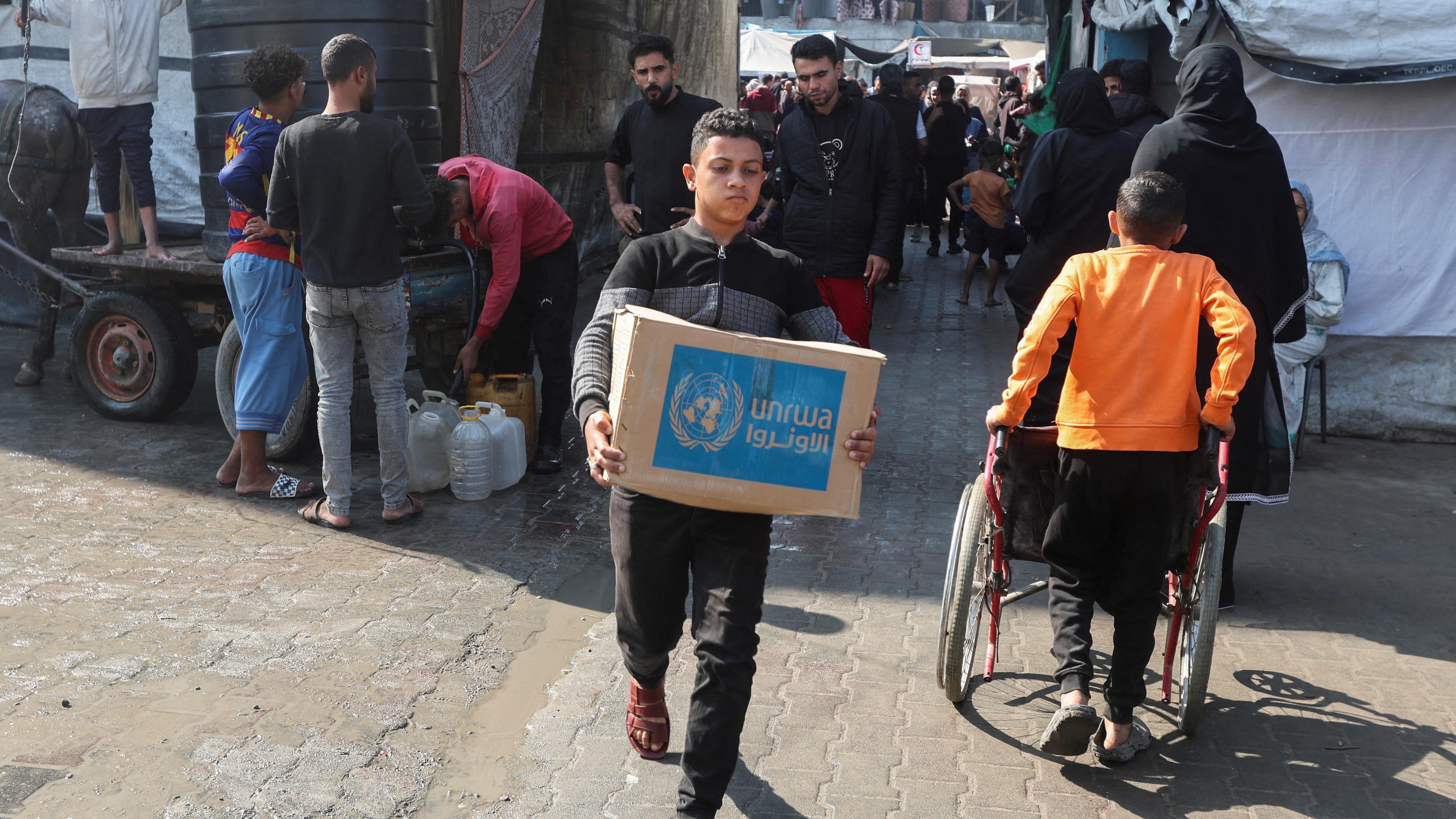 Un joven palestino carga una caja de asistencia distirbuida por UNRWA en Deir al-Balah, Gaza central (4 de noviembre 2024)