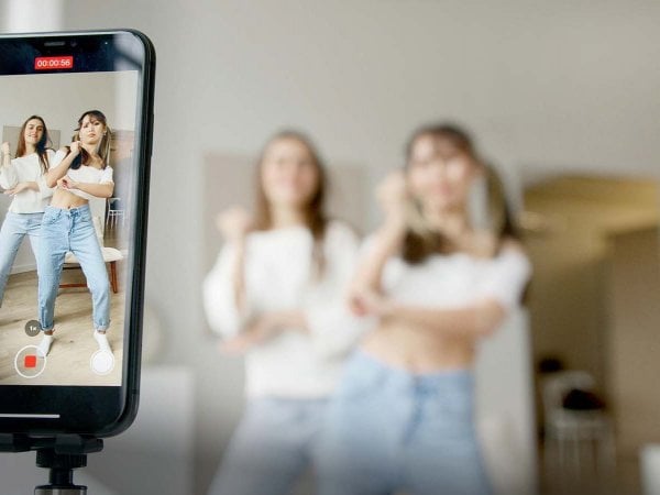 Grupo de influencers utilizando dispositivos móviles mientras comparten contenido en redes sociales.