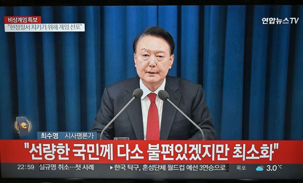 El presidente Yoon Suk-yeol, en la pantalla de una TV durante el anuncio de la imposición de la ley marcial.