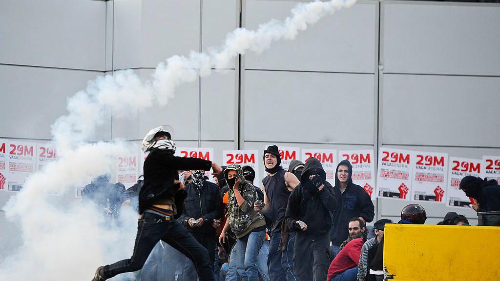 Un manifestante devuelve una bomba de gas lacrimógeno durante una huelga de 24 horas el 29 de marzo de 2012 en Barcelona, España.