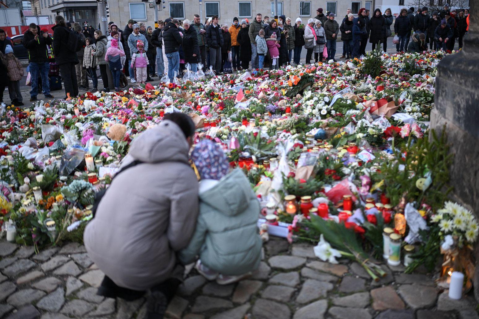 Numerosos ciudadanos depositan flores como tributo a las víctimas.