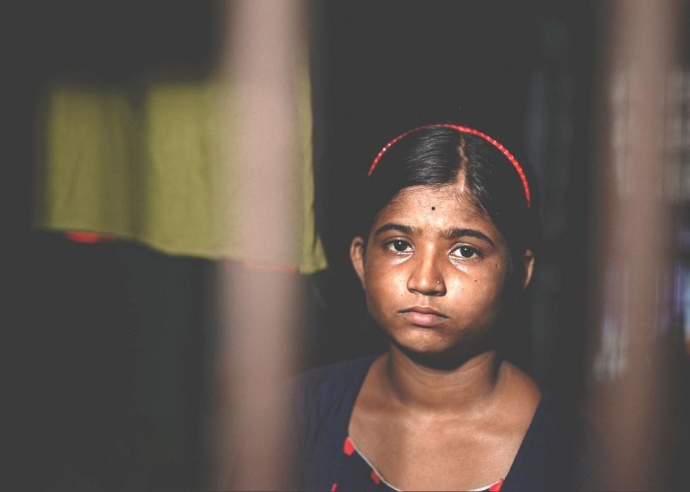 Niña mira por la ventana.
