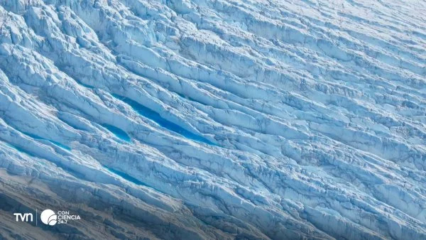 Vista aérea de grietas en la capa de hielo de Groenlandia, evidenciando el impacto del cambio climático.